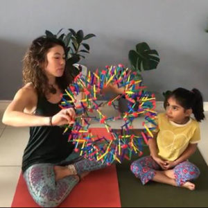 daycare little girl with yoga instructor and breathing ball