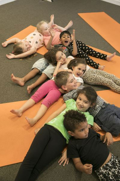 kids laying head to tummy in fun yoga session at daycare