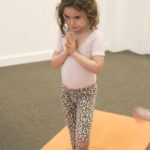 early learning student performing yoga at daycare class