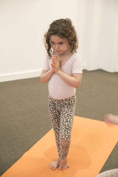 early learning student performing yoga at daycare class