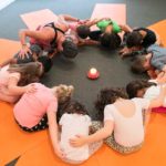 kindy class in circle around candle with teacher in yoga class