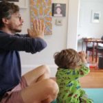 father and child practising yoga at home