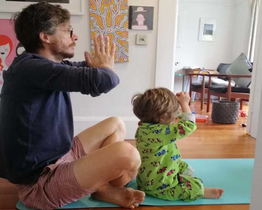 father and child practising yoga at home