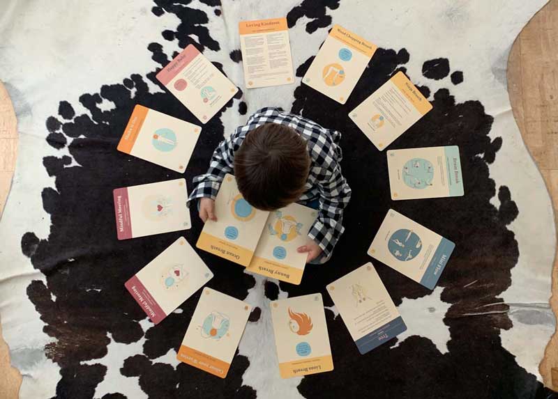 top shot of young boy surrounded by yoga cards
