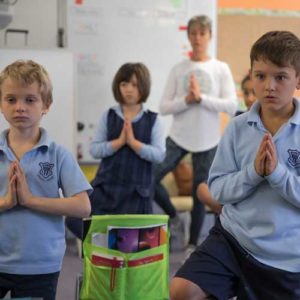 primary school yoga class with kids in tree pose