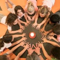 children learning mindfulness by watching a candle after doing a yoga class