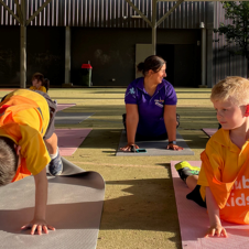 children in an OHSC activity doing downward dog yoga pose