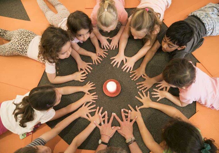 daycare yoga class kids with hands around candle